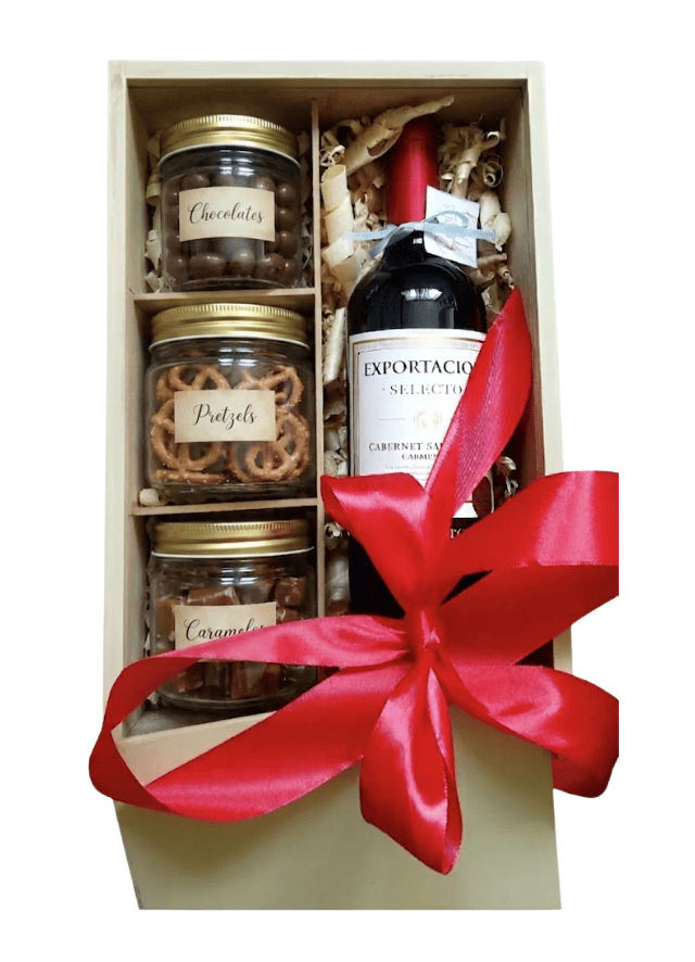 Caja de regalo con botella de vino, dulces, pretzels y caramelos.
